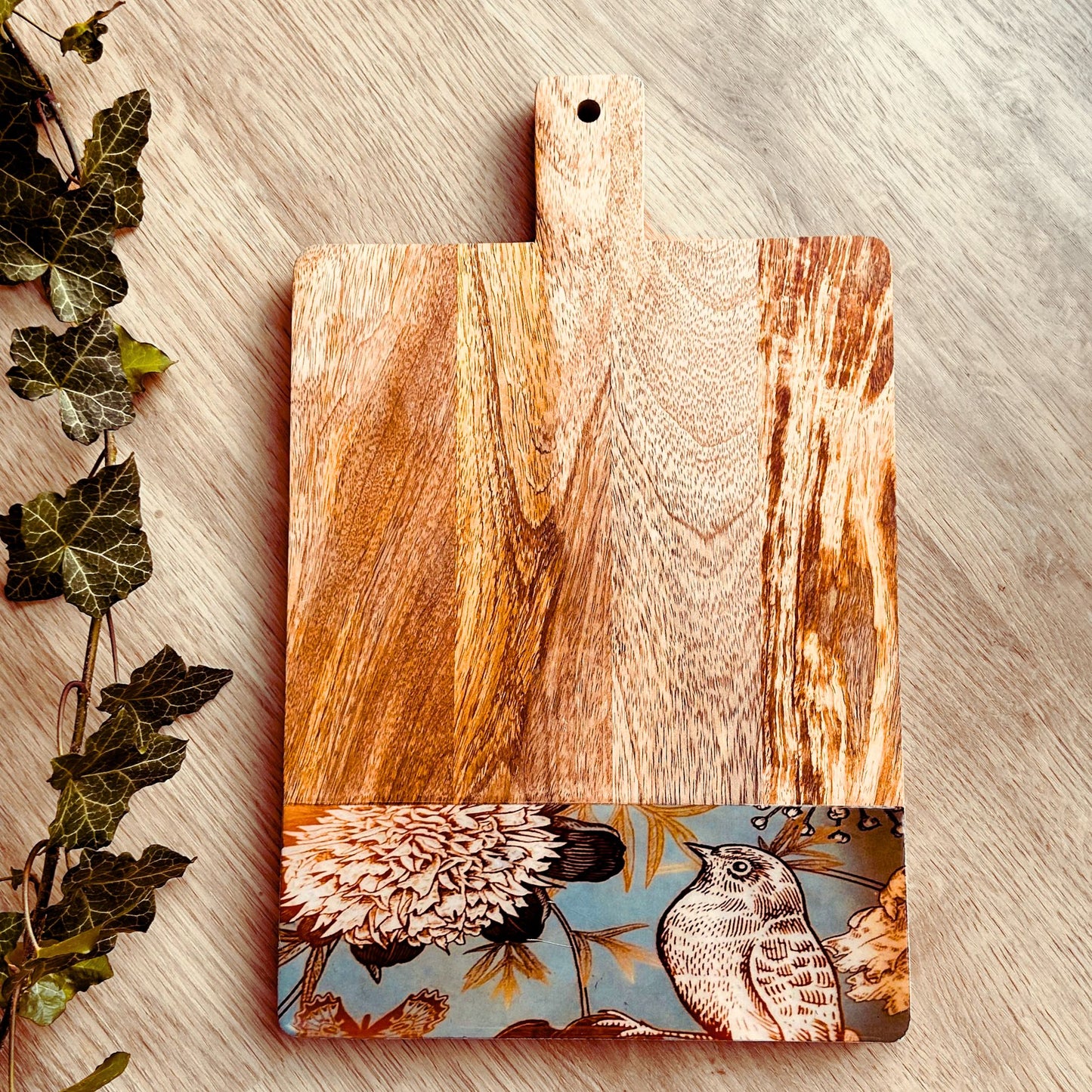 Mango Wood Cheese Board with handle. The Charcuterie Board has a nature, bird and flowers print at the bottom of the board.