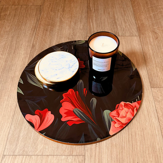 Floral printed Decorative Tray or Placemat placed on a wooden backdrop. It has a candle and white marble coasters kept on it.