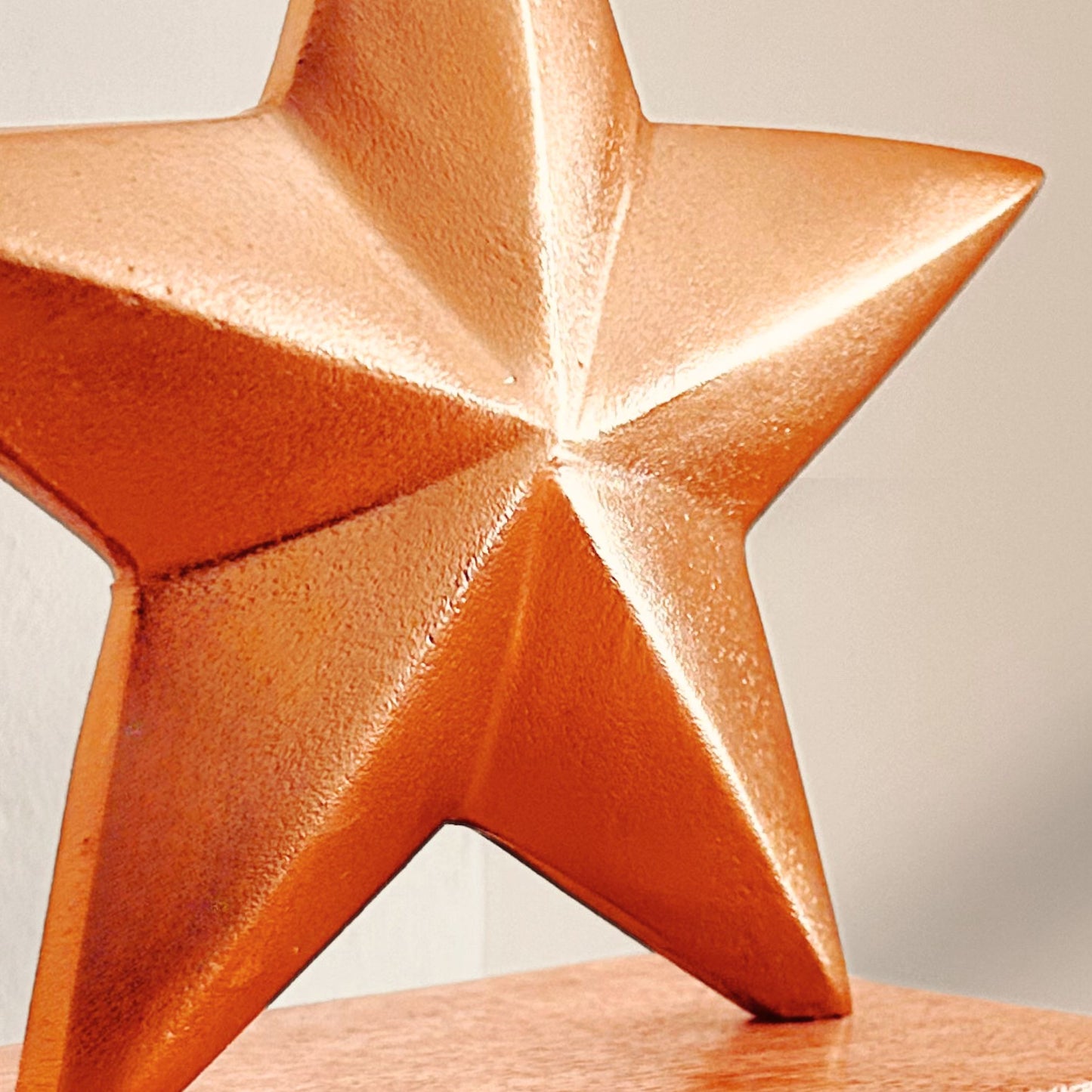 Close up shot a Brass Finish Star shaped stocking holder on a wooden base kept on a mantle.