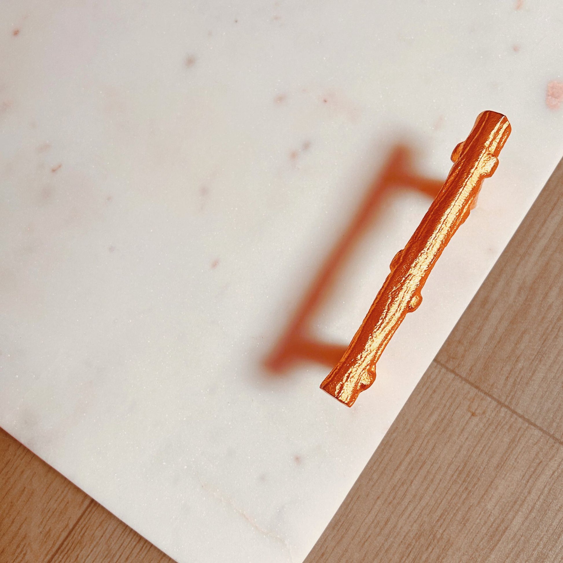 Close up of Metal handles in gold finish   for a Rectangular White Marble Tray.