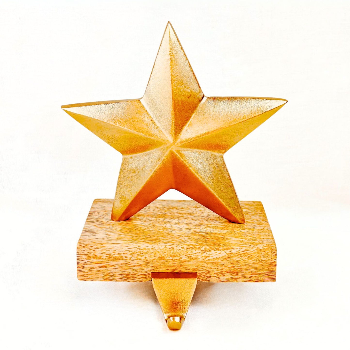 Brass Finish Star shaped Stocking Holder on a wooden base against a white background.