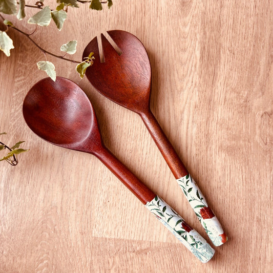 A pair of mango wood salad servers with nature print on the handle ends.