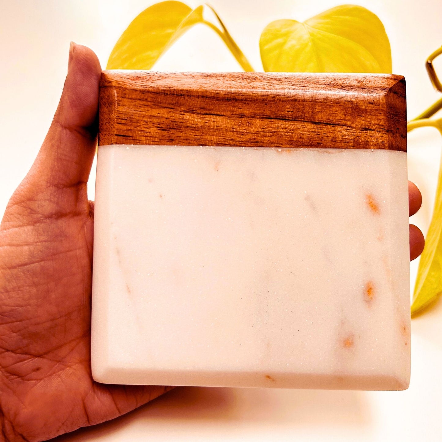 An Acacia and Marble Drink Coaster being held in the hand.