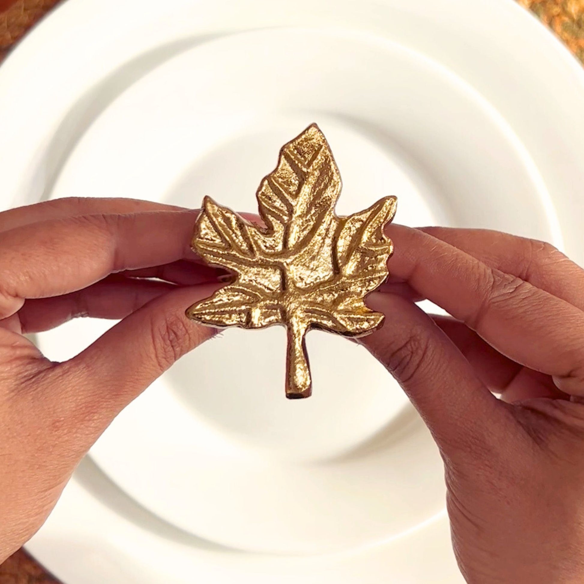 Model holding a Gold finish Leaf design Napkin Ring.