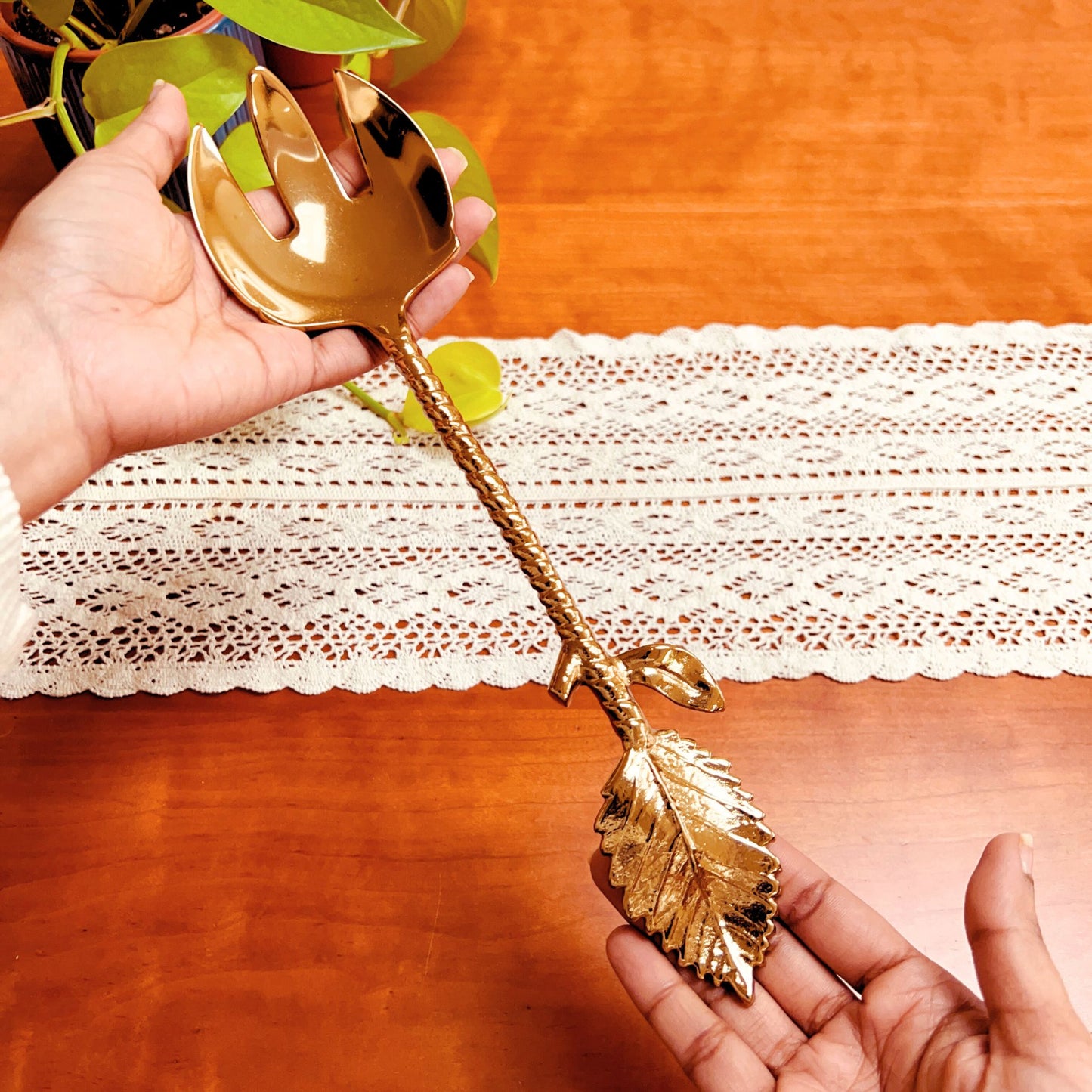 Model holding a Gold Finish Stainless Steel Salad Serving Fork with a twine and leaf handle.