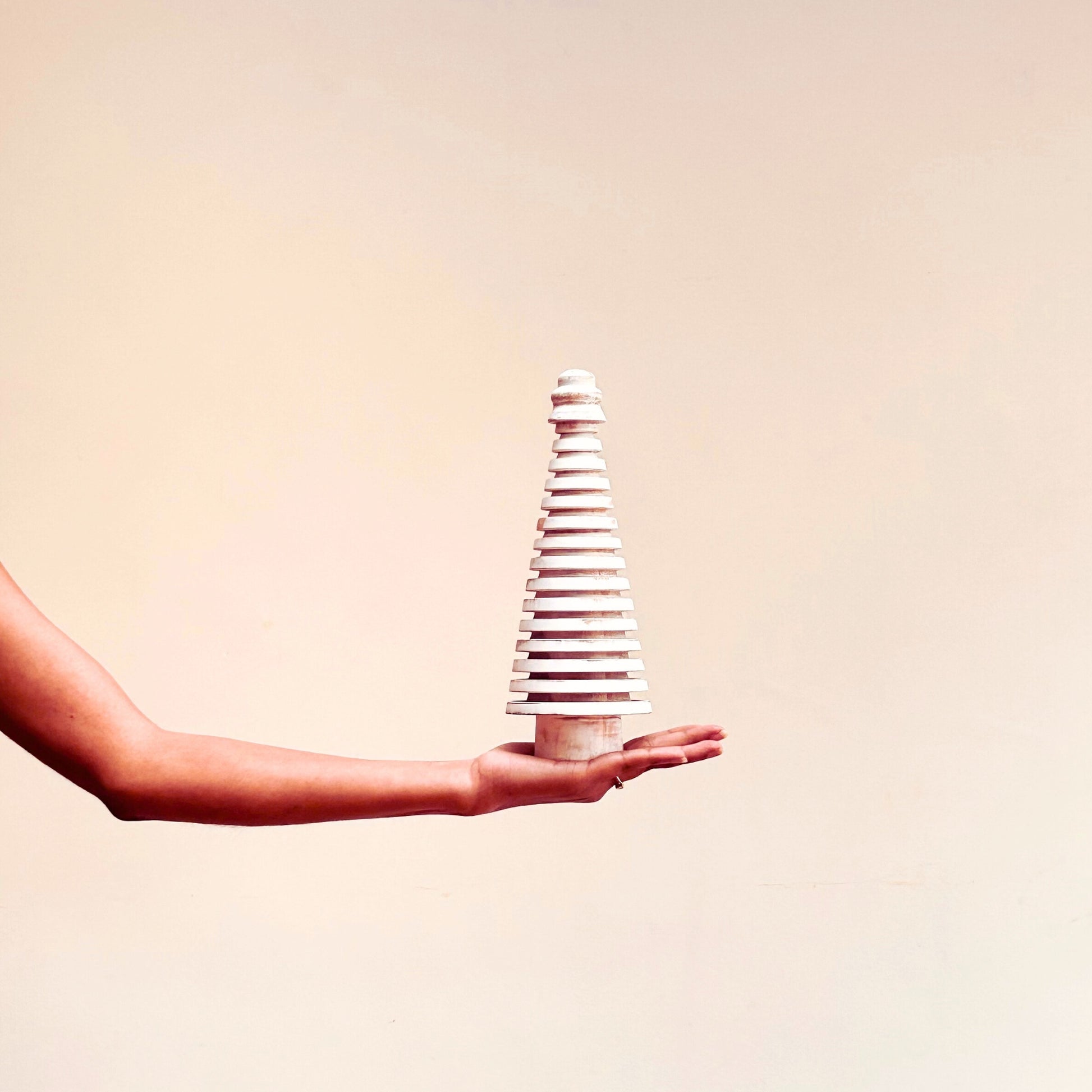 Model holding Rustic White Wooden Mango Tree in circular design.