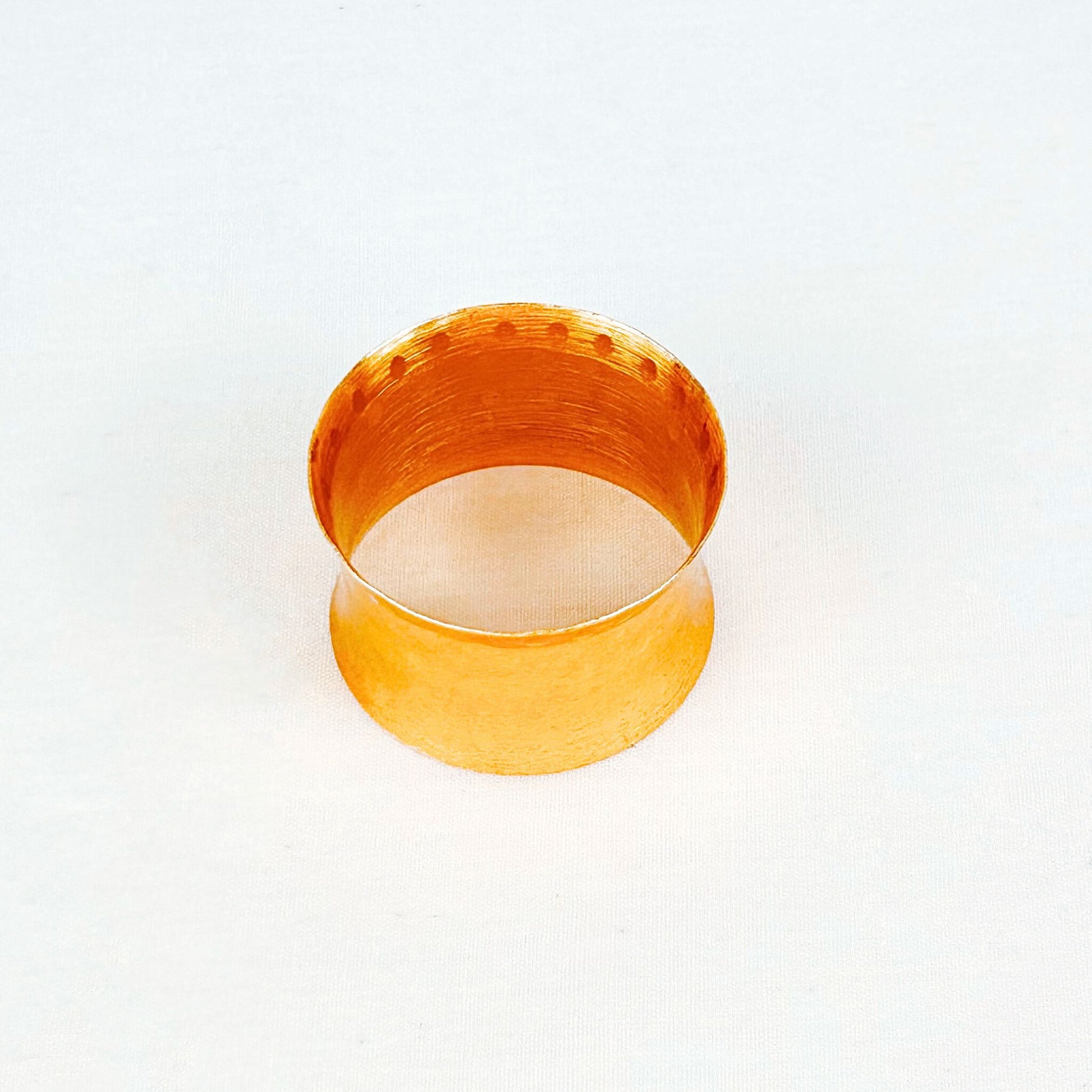 Top shot of a Gold Hammered Finish Napkin Ring on a white backdrop.