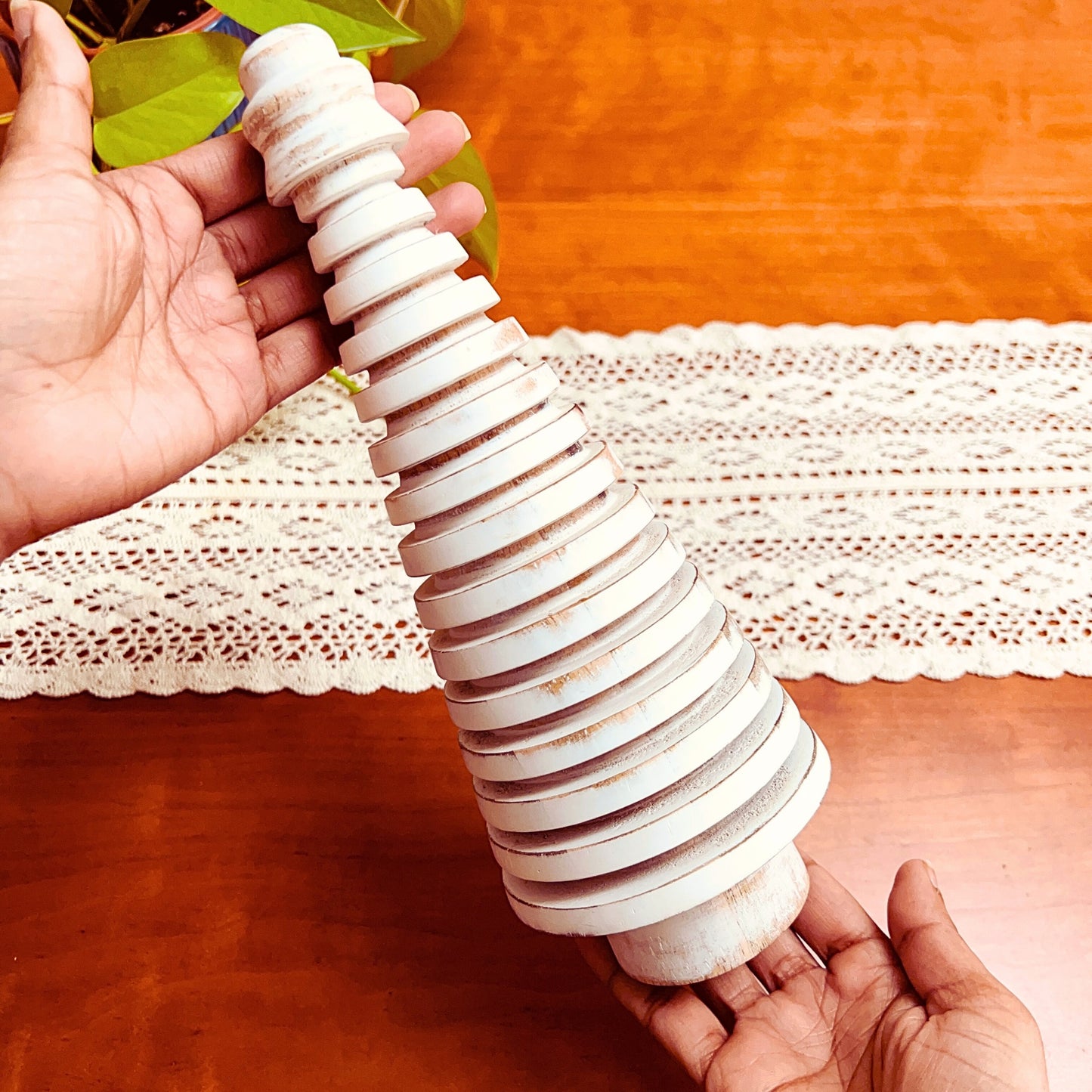 Model holding Rustic White Wooden Mango Tree in circular design.