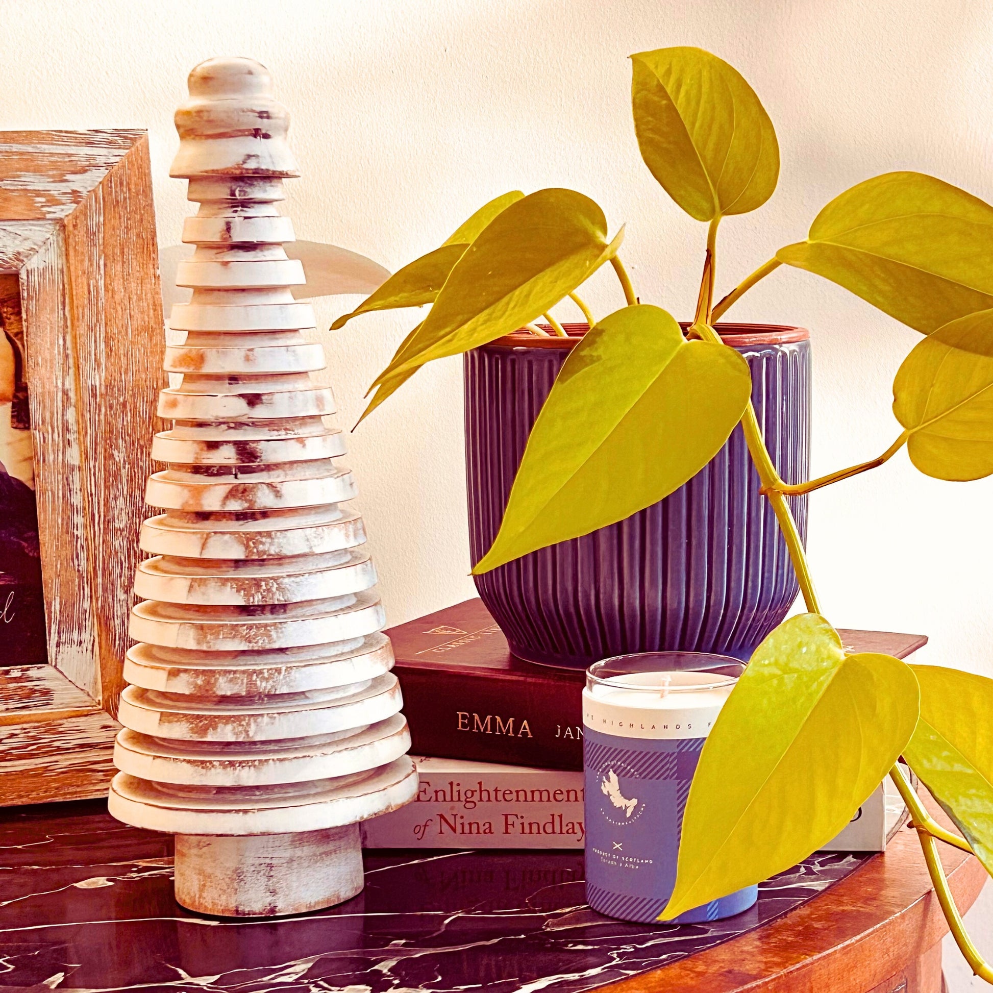 Rustic White Wooden Mango Tree in circular design kept on a table with a plant and candle next to it.