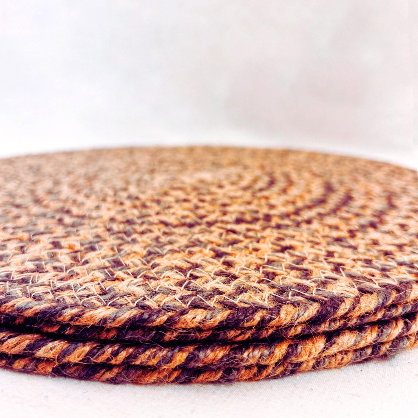 A stack of 4 100% Jute placemat on a white backdrop