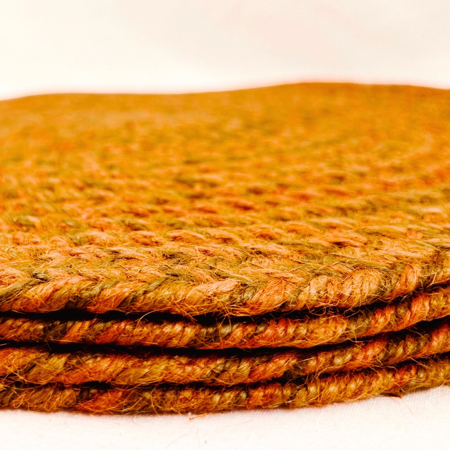 A stack of 4 100% Jute placemat on a white backdrop